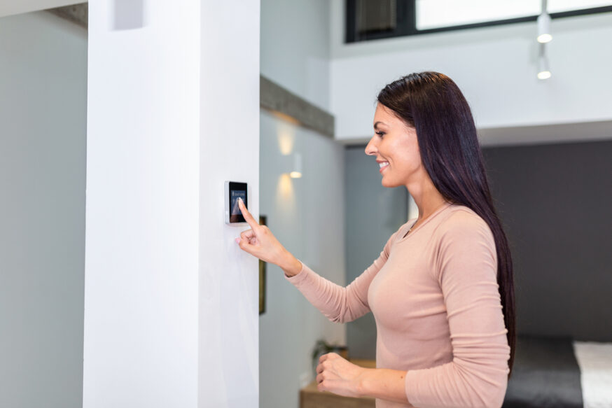 Woman,Using,Smart,Wall,Home,Control,System,In,Modern,Apartment.